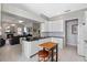 Bright, open kitchen with white cabinets, black countertops, stainless steel appliances, and adjoining living area at 1225 Hollow Pine Dr, Oviedo, FL 32765