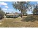 Spacious backyard with large trees, a grill, and a small lawn mower at 12419 Eryn Ct, Clermont, FL 34711
