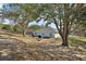 A large backyard with a grill and a garden plot underneath shady trees at 12419 Eryn Ct, Clermont, FL 34711