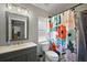 Charming bathroom with a floral shower curtain, gray vanity, and stylish mirror at 12419 Eryn Ct, Clermont, FL 34711