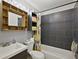 Modern bathroom featuring a gray tiled shower and decorative wooden shelving at 12419 Eryn Ct, Clermont, FL 34711