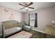 Bright, -friendly bedroom featuring a crib and cozy reading chair at 12419 Eryn Ct, Clermont, FL 34711