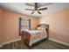 Bedroom with wooden floors and a wooden bed with bright colored quilt at 12419 Eryn Ct, Clermont, FL 34711