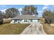 Single story home with a light blue exterior and a long driveway leading to the house at 12419 Eryn Ct, Clermont, FL 34711