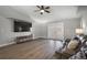 Bright living room with wood floors, a plush couch, and a mounted television at 12419 Eryn Ct, Clermont, FL 34711