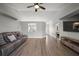 Inviting living room featuring light wood floors, modern ceiling fan, and a comfortable couch at 12419 Eryn Ct, Clermont, FL 34711