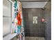 Modern shower featuring dark gray tiles, a glass shower curtain, and a rain shower head at 12419 Eryn Ct, Clermont, FL 34711