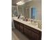 Bathroom showcasing a double vanity, framed mirror, and a shower with a glass door at 1259 Pando Loop, Orlando, FL 32824