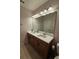 Bathroom with a double sink vanity, mirror, and modern lighting fixtures at 1259 Pando Loop, Orlando, FL 32824