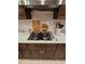 Modern kitchen featuring stainless steel stove, white countertops, and dark wood cabinets at 1259 Pando Loop, Orlando, FL 32824