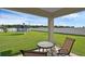 Covered outdoor patio area with table set and a view of the spacious backyard at 12835 Del Lago Dr, Astatula, FL 34705