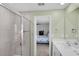 Bathroom with a glass-enclosed shower, vanity with sink and view to bedroom at 12835 Del Lago Dr, Astatula, FL 34705