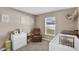 Bedroom featuring a crib, dresser, and seating area, creating a peaceful and organized baby space at 12835 Del Lago Dr, Astatula, FL 34705