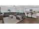Open living room with a large gray sectional, leading into a bright kitchen with barstool seating at 12835 Del Lago Dr, Astatula, FL 34705