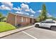 Side view of a red brick duplex with a manicured lawn and convenient parking, radiating curb appeal at 1288 Americana Pl, Orlando, FL 32807
