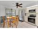 Kitchen boasts stainless steel appliances, white cabinets, and a wood dining table near sliding doors at 1288 Americana Pl, Orlando, FL 32807