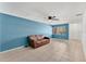 Inviting living room with blue walls, tile flooring, and a cozy brown leather sofa beneath a ceiling fan at 1288 Americana Pl, Orlando, FL 32807