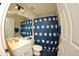 Bathroom features single vanity, toilet, and shower with a decorative blue shower curtain at 130 Winsor Ave, Davenport, FL 33837