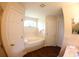 Bright bathroom features a soaking tub, white doors, wood floors, and neutral wall color at 130 Winsor Ave, Davenport, FL 33837