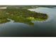 Stunning aerial view of a property situated on a peninsula surrounded by water and lush greenery at 1443 Stone Trl, Enterprise, FL 32725