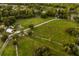 Aerial view of a large green field with scattered trees and access roads at 1443 Stone Trl, Enterprise, FL 32725