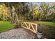 Wooden gate leading to a secluded backyard surrounded by lush trees and greenery at 1443 Stone Trl, Enterprise, FL 32725