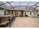 Spacious screened-in patio with an outdoor kitchen, bar seating, and access to the pool area at 1443 Stone Trl, Enterprise, FL 32725