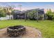 Picturesque backyard featuring a brick firepit with mature landscaping within the screened enclosure at 1443 Stone Trl, Enterprise, FL 32725
