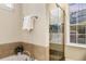 Modern bathroom featuring a glass shower, a tub, and a large window with natural light at 1443 Stone Trl, Enterprise, FL 32725
