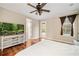 Bedroom with hardwood floors, tv and view to backyard with pool at 1443 Stone Trl, Enterprise, FL 32725
