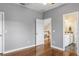 Neutral-toned bedroom with hardwood floors with an open doorway to a bathroom and hallway at 1443 Stone Trl, Enterprise, FL 32725