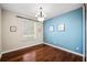 Stylish bedroom with hardwood floors, complemented by a modern chandelier and bright natural light from the window at 1443 Stone Trl, Enterprise, FL 32725