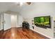 Bonus room featuring hardwood flooring, flatscreen tv, and built-in shelving at 1443 Stone Trl, Enterprise, FL 32725