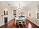 Elegant dining room with hardwood floors, fireplace, chandelier, and natural light from multiple windows at 1443 Stone Trl, Enterprise, FL 32725