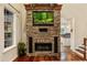 Beautiful stone fireplace and mantel in a living room setting, complete with a mounted television and hardwood floors at 1443 Stone Trl, Enterprise, FL 32725