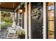 Charming front door with wreath, rocking chairs and brick porch detail at 1443 Stone Trl, Enterprise, FL 32725