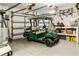 Garage interior with a golf cart, storage shelves, and ample space for parking and equipment at 1443 Stone Trl, Enterprise, FL 32725