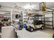Garage interior with beige golf cart, e-bike, and plenty of shelving for storage at 1443 Stone Trl, Enterprise, FL 32725