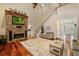Cozy living room with stone fireplace and hardwood flooring, two-story ceiling, and staircase at 1443 Stone Trl, Enterprise, FL 32725