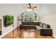 Cozy living room features hardwood floors, a sectional sofa, and a wall-mounted TV for entertainment at 1443 Stone Trl, Enterprise, FL 32725