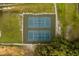 Aerial view of well-maintained tennis courts nestled in a lush, green landscape at 1443 Stone Trl, Enterprise, FL 32725