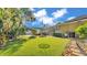 Spacious backyard with artificial turf, mature landscaping, and a fun swing set for recreation at 1455 Royal Forest Loop, Lakeland, FL 33811