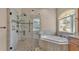 Bathroom with a luxurious glass enclosed shower and soaking tub near a window at 1455 Royal Forest Loop, Lakeland, FL 33811