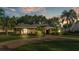 Charming single-story home featuring a circular brick driveway and lush, tropical landscaping at 1455 Royal Forest Loop, Lakeland, FL 33811