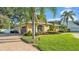 Attractive home featuring a well-maintained lawn, mature trees and a circular driveway at 1455 Royal Forest Loop, Lakeland, FL 33811