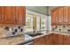 Bright kitchen with granite counters, wood cabinets, and a view of the pool at 1455 Royal Forest Loop, Lakeland, FL 33811