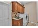 Laundry room featuring wooden cabinets, granite countertop, and a washer/dryer at 1455 Royal Forest Loop, Lakeland, FL 33811