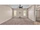 Spacious living room featuring neutral carpet, ceiling fan, and natural light from the windows at 1455 Royal Forest Loop, Lakeland, FL 33811