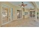 Screened in patio with multiple entry doors and two ceiling fans at 1455 Royal Forest Loop, Lakeland, FL 33811