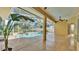 Enclosed pool area with tile flooring, ceiling fan, and lush landscaping at 1455 Royal Forest Loop, Lakeland, FL 33811